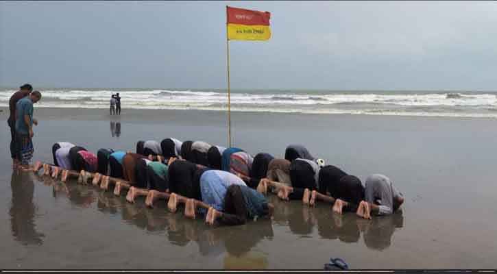 সমুদ্র বালুচরে নামাজে মগ্ন পর্যটকরা