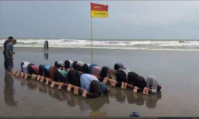 সমুদ্র বালুচরে নামাজে মগ্ন পর্যটকরা
